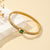 Gold bracelet with a green gemston